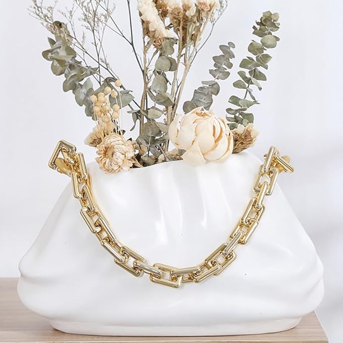 Modern resin vase holding dried flowers on table
