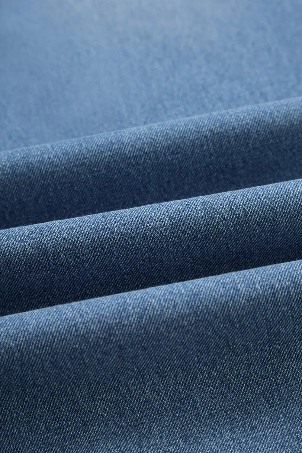 Jeans laid flat showing tapered legs and back pockets

