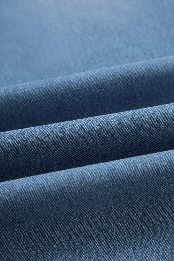 Jeans laid flat showing tapered legs and back pockets

