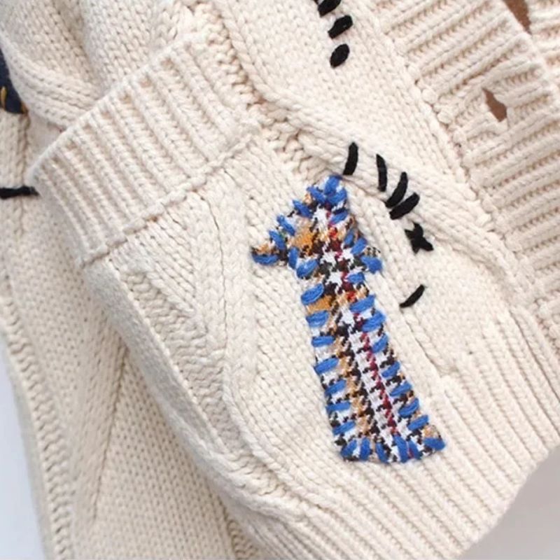 Folded knit cardigan showing lightweight texture and ribbed trim

